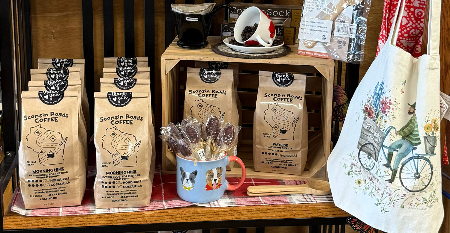 Bags of Sconsin Roads Coffee, coffee cup with flavored spoons, aprons