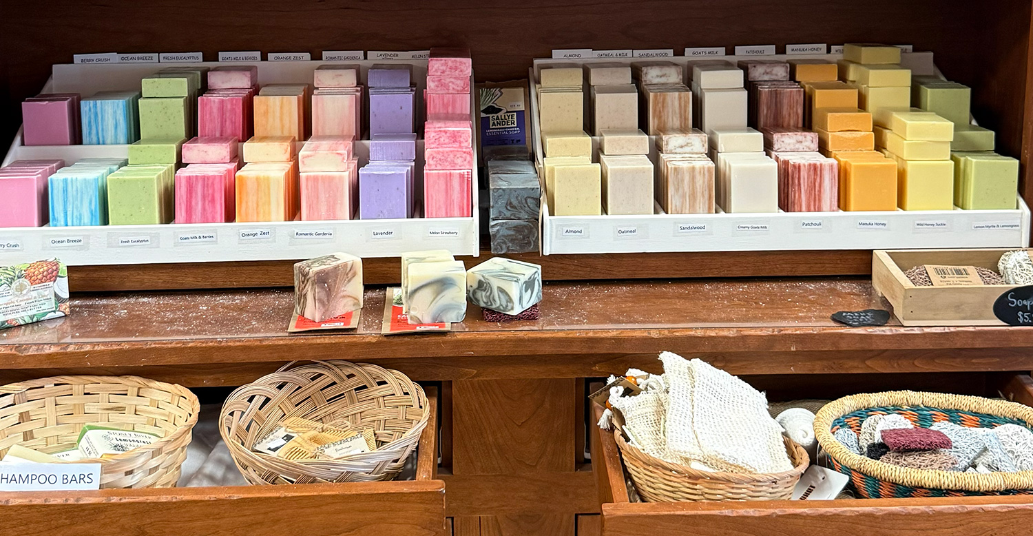 Shelves of specialty soaps. Drawer with baskets of soaps and wash cloths
